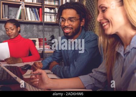 Young smiling business man and woman working together in the office analyzing the positive results achieved Stock Photo