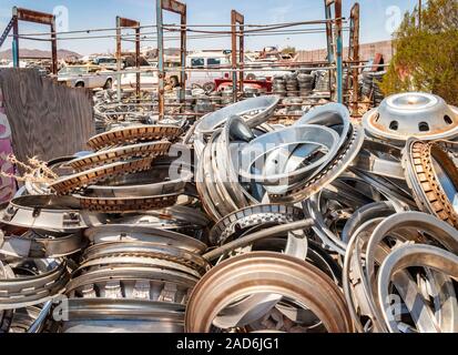 old car and truck chrome grilles stacked in a junk yard in the desert ...