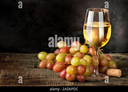 Glass of white wine with grapes Stock Photo