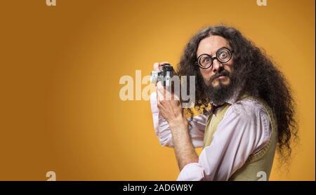 Portrait of a funny nerd taking a picture with a new digital camera Stock Photo