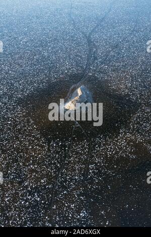 Stone in a frozen lake, Lapland, Sweden Stock Photo