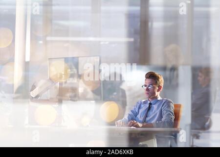 man working on computer in dark office Stock Photo