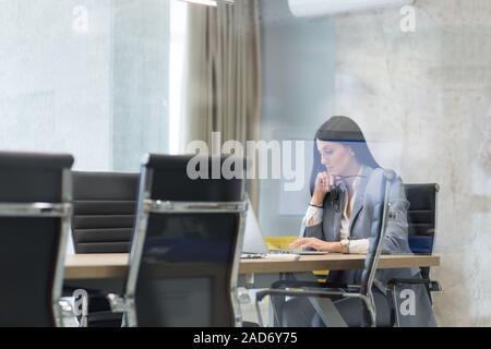 Businesswoman using a laptop in startup office Stock Photo