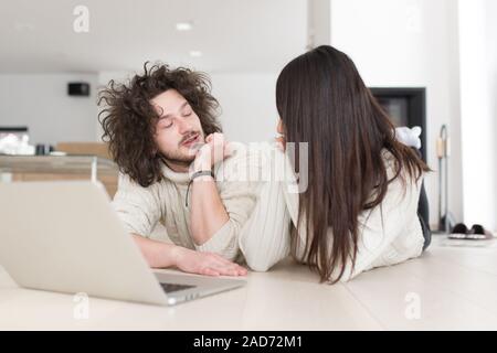 young multiethnic couple using a laptop on the floor Stock Photo