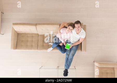 young couple in living room using tablet top view Stock Photo