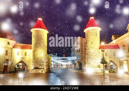 Decorated and illuminated Christmas Guard towers of Viru Gate and narrow street of Old Town at night, Tallinn, Estonia Stock Photo