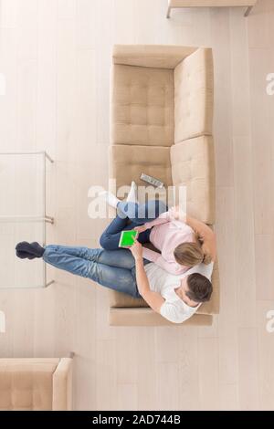 young couple in living room using tablet top view Stock Photo