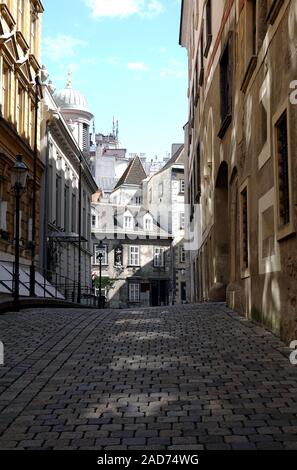 Quiet stone paving city street with old vintage houses in the center of Vienna on bright sunny day vertical view Stock Photo