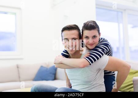 handsome man piggybacking his girlfriend Stock Photo