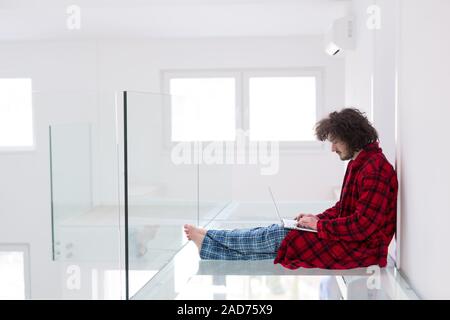 young freelancer in bathrobe working from home Stock Photo