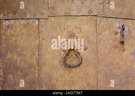 Rusty metal plates with rivets and door handle as background Stock Photo