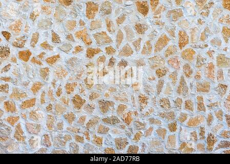 Background from a rough beige natural stone wall Stock Photo