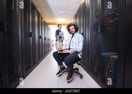 Team of young technicians working together on servers Stock Photo