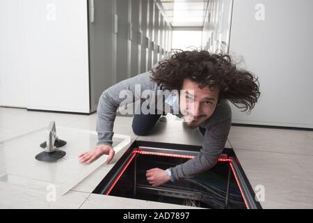 engineer connecting cables in server room Stock Photo