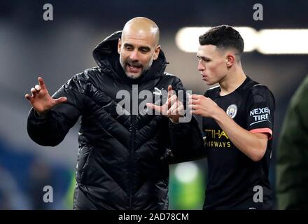 Manchester City manager Pep Guardiola (left) celebrates their victory with Phil Foden after the final whistle during the Premier League match at Turf Moor, Burnley.