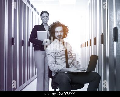 Team of young technicians working together on servers Stock Photo