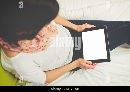 woman using tablet sitting on the bed Stock Photo