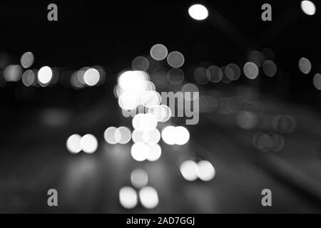 Night city lights. Illumination and lighting. White and red blurred lamps. Watching transport moving in street. Urban traffic. Blurred car lights night. Urban night. Lights defocused background. Stock Photo