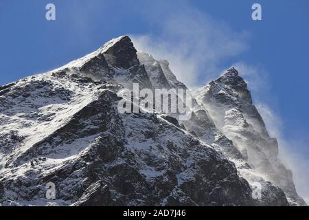 Strong winds blowing snow over mountain peaks in the Himalayas. Stock Photo