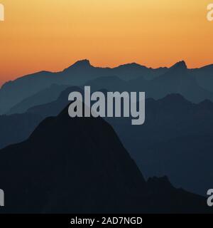 Sunset view from Mount Brienzer Rothorn, Switzerland. Outlines of Mount Tannhorn and other mountains Stock Photo