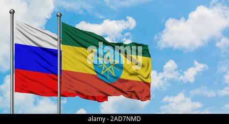 Russia and Ethiopia flag waving in the wind against white cloudy blue sky together. Diplomacy concept, international relations. Stock Photo