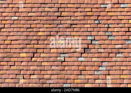 Background from a house wall made of red old shingles Stock Photo