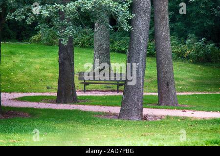 Park, alder, lawn, park paths and old park bench Stock Photo