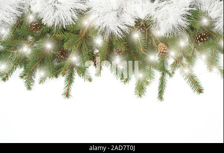 Natural Christmas layout of Christmas tree branches, cones and golden Christmas lights with bokeh on isolated white background. Flat lay. Copy space. Stock Photo