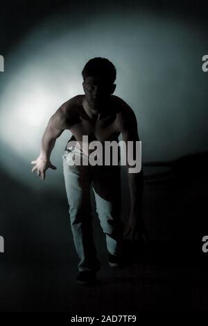 Silhouette standing man in the darkness. Studio shoot. Stock Photo