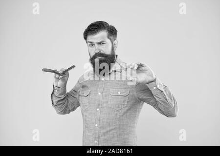 Classic values. Retro barbershop. Hipster with tools. Designing haircut. Fresh hairstyle. Barbershop concept. Barbershop salon. Personal stylist. Vintage barber. Bearded man hold razor and scissors. Stock Photo