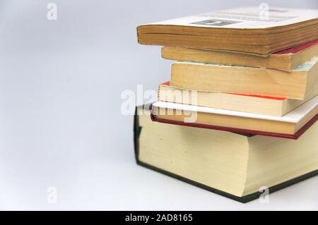 A pile of thick books on a table with white background with copy space on the left Stock Photo