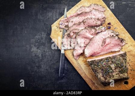 Traditional lunch meat with sliced cold cuts roast beef  as top view on a cutting board with copy space left Stock Photo