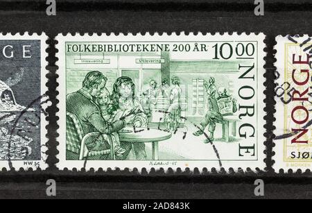 SEATTLE WASHINGTON - November 28, 2019: Close up of postage in black stock album page. Families, men and women at Public Library on Norway Stamp. Scot Stock Photo