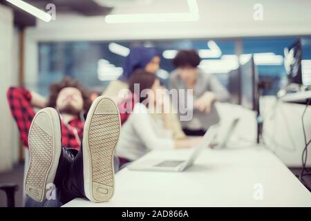 software developer resting with legs on desk Stock Photo