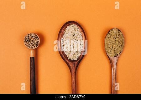 Different types of uses for hemp. Seeds, protein and powder in wooden spoons. Stock Photo