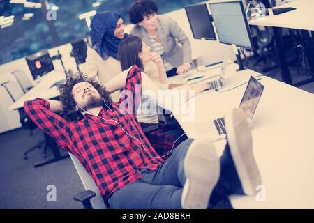 software developer resting with legs on desk Stock Photo