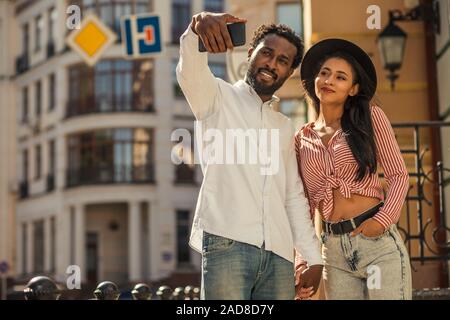 Young man looking confident while taking selfie with girlfriend Stock Photo