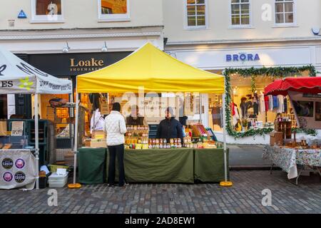 Stalls at the popular roadside winter street market in the pedestrianised area of High Street, Guildford, county town of Surrey, southeast England, UK Stock Photo