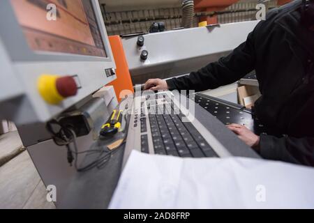 carpenters calculating and programming a cnc wood working machine Stock Photo