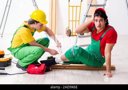 Injured worker and his workmate Stock Photo