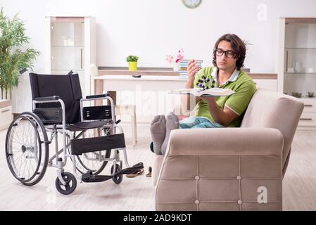 Young male student in wheelchair at home Stock Photo