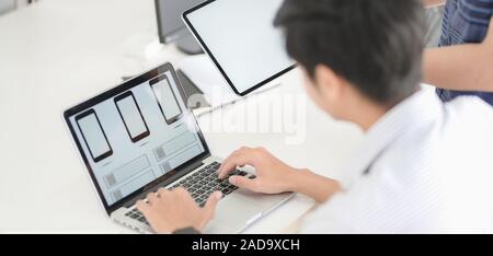 Close-up view of UI graphic designer planing on his smartphone template application with laptop computer Stock Photo