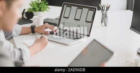 Cropped shot of young professional UX web developer working on smartphone template together Stock Photo
