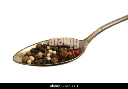 A mixture of peppers in a spoon on isolate. View from above. Seasoning in an old spoon isolated on a white background. Close-up. Stock Photo