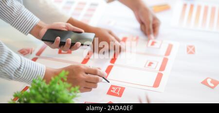 Cropped shot of young UX graphic designer team working on smartphone template together Stock Photo