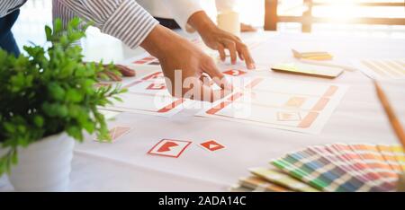Close-up view of young professional UI web developer working on smartphone application together Stock Photo