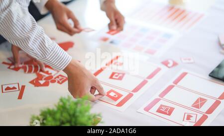 Group of professional UX graphic designer discussing the smartphone template project together in modern office room Stock Photo