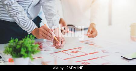 Group of professional UX graphic designer discussing the smartphone template project together in modern office room Stock Photo