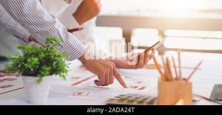 Cropped shot of young professional UX web developer team working on smartphone template together Stock Photo