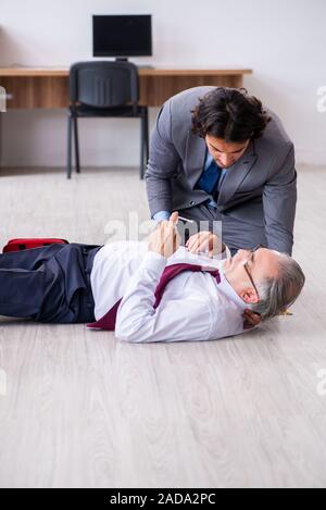 Male employee suffering from heart attack in the office Stock Photo